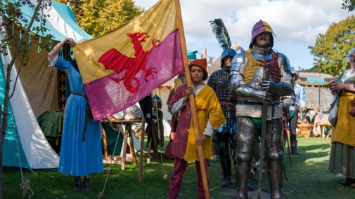 Knights in line ready for battle with child holding out a flag